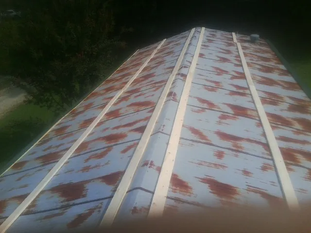 Rusted metal roof panels with new wood purlins before replacement — Storm Damage Roof Repair in Semmes by Roofing Brothers
