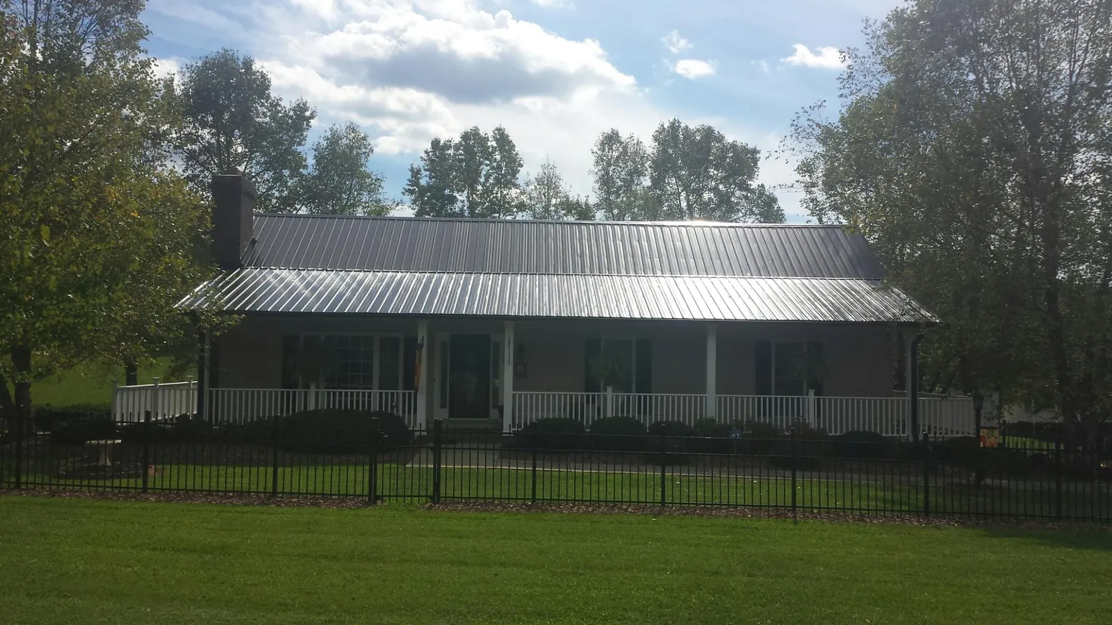 Gray metal roof on a brick ranch with a full width front porch — Gutter Guard Installation work by our crew in Semmes