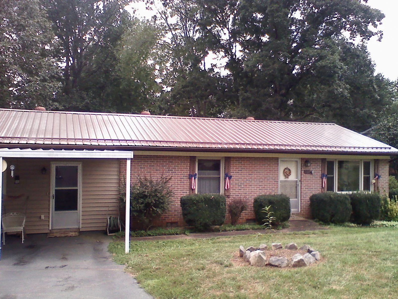 Bronze metal roof and carport on a brick ranch home — Roof Repair work by our crew in Semmes