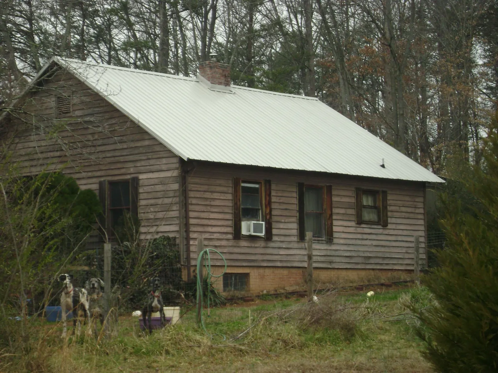 White metal roof on an old wood sided farmhouse, from a Asphalt Shingle Roof Repair job in Semmes